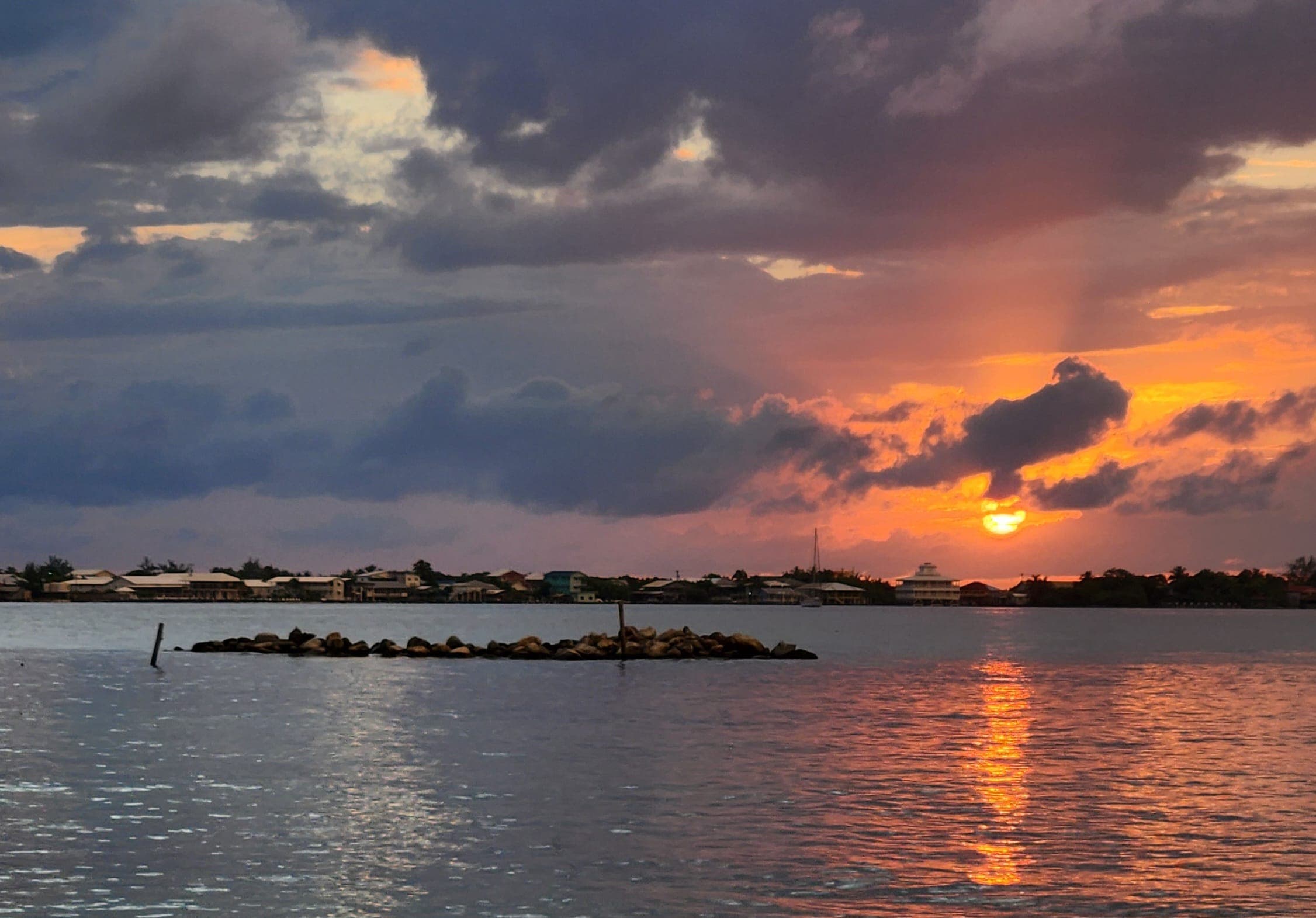 Sunset over the water and rooftops of Utila